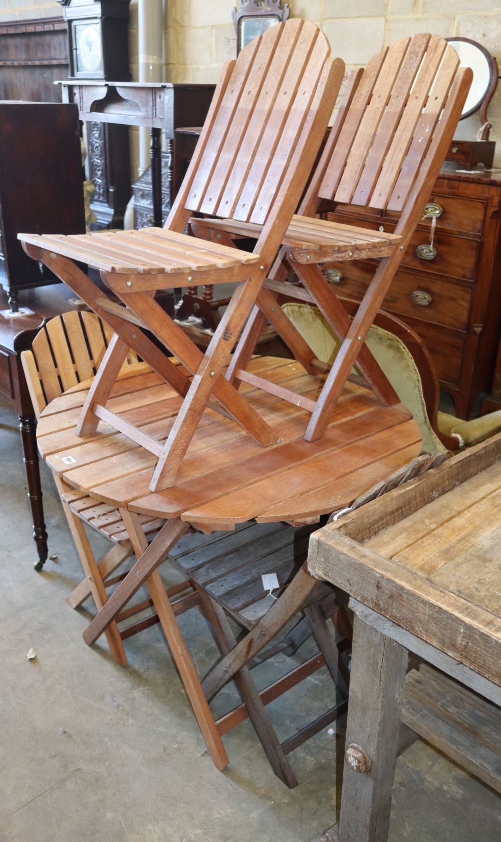 A circular teak folding garden table and four chairs, table 90cm diameter